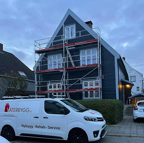 Hvit arbeidsbil utenfor hus